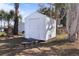 Storage shed in backyard surrounded by lush landscaping providing extra outdoor storage and functionality at 215 Washington Ave, Englewood, FL 34223