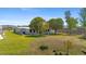 The backyard offers a spacious grassy area bordered by mature trees and partial fencing at 2255 Easy St, Port Charlotte, FL 33952