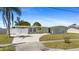 Charming single-story home with a spacious front yard, long driveway, and white privacy fence at 2255 Easy St, Port Charlotte, FL 33952