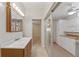 Bathroom connected to a hallway with white cabinets, drawers, and countertops at 2255 Easy St, Port Charlotte, FL 33952