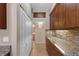 Open kitchen area with modern cabinets and granite countertops, looking towards bathroom and storage at 2255 Easy St, Port Charlotte, FL 33952