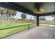 View of a screened in back porch overlooking a lawn and fence, complete with ceiling fan and lights at 23283 Duchess Ave, Port Charlotte, FL 33954