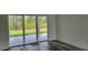Bright living room featuring sliding glass doors, wood-look flooring, and neutral paint at 23490 Macbeth Ct, Punta Gorda, FL 33980