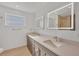 Bright bathroom featuring double vanity with square lit mirrors, and modern finishes at 2501 Rio Grande Dr, Punta Gorda, FL 33950