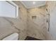 Newly remodeled shower featuring rain shower head, handheld wand, and marble-style tiling at 2501 Rio Grande Dr, Punta Gorda, FL 33950