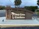 Elegant entrance sign for Deep Creek Gardens community with lush landscaping and illuminated signage at 25100 Sandhill Blvd # I201, Punta Gorda, FL 33983