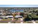 Aerial view of a cozy residential property with mature trees, a pool, and a serene lake in the background at 2550 Ivanhoe St, Port Charlotte, FL 33952