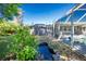 Backyard featuring lush greenery, a tranquil pond, and a screened-in pool enclosure, a nature lover's dream at 2550 Ivanhoe St, Port Charlotte, FL 33952