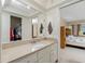 Clean and well-lit bathroom featuring a spacious vanity, sink, and access to the walk-in closet and bedroom at 2550 Ivanhoe St, Port Charlotte, FL 33952
