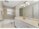 Bright bathroom featuring a tub-shower combo, neutral tile, and a large vanity with ample storage at 2550 Ivanhoe St, Port Charlotte, FL 33952