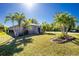 Charming single-story home showcasing a well-manicured lawn and lovely curb appeal with mature palms at 2550 Ivanhoe St, Port Charlotte, FL 33952