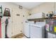 Functional laundry room equipped with a washer, dryer, and storage cabinets at 2550 Ivanhoe St, Port Charlotte, FL 33952