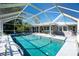Enjoy this beautiful screened-in pool surrounded by lush landscaping and a spacious patio at 2550 Ivanhoe St, Port Charlotte, FL 33952