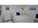 Bedroom with white furniture, window, and a beautifully made queen size bed with blue and white accents at 27500 Janzen Ct, Englewood, FL 34223