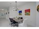 Contemporary dining area featuring modern lighting, a rustic table, and stylish decor, creating an inviting space at 27500 Janzen Ct, Englewood, FL 34223