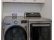 Laundry room with stainless steel front loading washer and dryer at 27500 Janzen Ct, Englewood, FL 34223