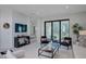 Bright, modern living room with sliding glass doors and comfortable seating arrangement, plus a glimpse into an adjacent bedroom at 27500 Janzen Ct, Englewood, FL 34223