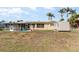 Home's backyard featuring a shed, sliding glass doors, and a view of palm trees in the distance at 3100 Magnolia Way, Punta Gorda, FL 33950