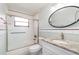 Bright bathroom featuring a shower over tub combination, granite vanity top and oval mirror at 3100 Magnolia Way, Punta Gorda, FL 33950