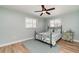 Light bedroom with wood floors, and a double window with shuttered blinds at 3100 Magnolia Way, Punta Gorda, FL 33950