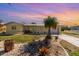 Inviting single-story home featuring a lush landscaped yard and charming curb appeal at sunset at 3100 Magnolia Way, Punta Gorda, FL 33950