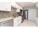 Modern kitchen with stainless steel appliances, white cabinets, and stylish backsplash at 3100 Magnolia Way, Punta Gorda, FL 33950