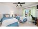 Bright bedroom with twin beds, ceiling fan, and a window providing natural light and neighborhood views at 311 Garvin St # 401C, Punta Gorda, FL 33950
