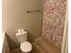 Cozy bathroom featuring floral shower curtains, a toilet, and a towel bar at 3209 Sunrise Trl, Port Charlotte, FL 33952