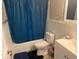 Cozy bathroom with tub, toilet, and sink with vanity, features a blue shower curtain at 3209 Sunrise Trl, Port Charlotte, FL 33952