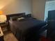 Comfortable bedroom featuring a plush bed with striped bedding and a side table with a lamp at 3209 Sunrise Trl, Port Charlotte, FL 33952