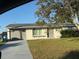 Charming single-story home featuring an attached garage, well-maintained lawn, and mature trees at 3209 Sunrise Trl, Port Charlotte, FL 33952
