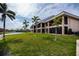 Condominium backyard featuring a well-maintained lawn, palm trees, and waterfront access at 3256 White Ibis Ct # 13B, Punta Gorda, FL 33950