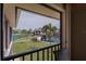 Balcony view of the tennis court, palm trees, and nearby pool area at 3256 White Ibis Ct # 13B, Punta Gorda, FL 33950