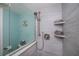 Modern tiled bathroom featuring a glass-enclosed shower with dual floating shelves at 3256 White Ibis Ct # 13B, Punta Gorda, FL 33950