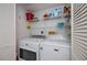 Well-equipped laundry room featuring modern washer and dryer units with shelving at 3256 White Ibis Ct # 13B, Punta Gorda, FL 33950