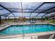 Inviting pool area featuring clear water, lounge chairs, and an overhead screen at 3256 White Ibis Ct # 13B, Punta Gorda, FL 33950