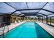 Community pool with large screened-in area and lounge chairs at 3256 White Ibis Ct # 13B, Punta Gorda, FL 33950