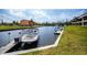 Scenic waterfront view with a boat docked and surrounding lush greenery at 3256 White Ibis Ct # 13B, Punta Gorda, FL 33950