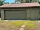 A detached garage with a roll-up door and side entrance, surrounded by a grassy yard and stepping stones at 4381 Northshore Dr, Punta Gorda, FL 33980