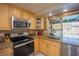 Sunlit kitchen with stainless steel appliances, granite countertops and a view of the pool at 4381 Northshore Dr, Punta Gorda, FL 33980
