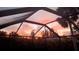 Captured through the lanai's screen, a vibrant sunset sky, adding privacy and enhancing the property's natural beauty at 4381 Northshore Dr, Punta Gorda, FL 33980