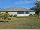 The backyard features a lush green lawn with mature landscaping providing privacy and a serene outdoor space at 501 San Cristobal Ave, Punta Gorda, FL 33983