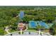 Overhead view of tennis courts with adjacent clubhouse, walking path and tropical landscaping at 5017 Hanging Moss Ln, Sarasota, FL 34238
