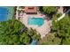 Aerial view of the community pool and tennis courts surrounded by lush green trees and landscaping at 5017 Hanging Moss Ln, Sarasota, FL 34238