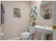 Powder room featuring a pedestal sink, framed art and adjacent toilet at 5017 Hanging Moss Ln, Sarasota, FL 34238