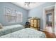 Bedroom with two twin beds, window with blinds, and a glimpse into the hallway, enhancing its spacious feel at 5017 Hanging Moss Ln, Sarasota, FL 34238