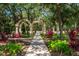 Picturesque community entrance featuring a stone archway, lush landscaping, and a shaded walkway at 5017 Hanging Moss Ln, Sarasota, FL 34238