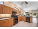 Well-lit kitchen featuring tile flooring, wood cabinets, updated appliances and bar stool seating at 5017 Hanging Moss Ln, Sarasota, FL 34238