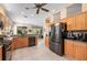 Bright kitchen featuring stainless steel appliances, wood cabinets, granite countertops and adjacent living room at 5017 Hanging Moss Ln, Sarasota, FL 34238