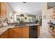 Bright kitchen featuring stainless steel appliances, wood cabinets, granite countertops and adjacent living room at 5017 Hanging Moss Ln, Sarasota, FL 34238
